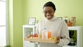 African american woman smiling confident holding breakfast tray at dinning room Royalty Free Stock Photo