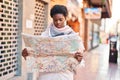 African american woman smiling confident holding city map at street Royalty Free Stock Photo