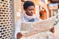 African american woman smiling confident holding city map at street Royalty Free Stock Photo