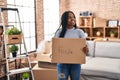 African american woman smiling confident holding fragile package at new home