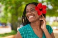 African american woman smiling confident wearing flower on ear at park Royalty Free Stock Photo