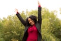 African American woman smiling with open arms.