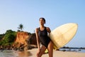 African american woman standing with surfboard on ocean beach. Black female surfer posing with surf board. Pretty