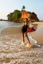 African american woman standing with surfboard on ocean beach. Black female surfer posing with surf board. Pretty