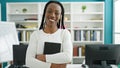 African american woman student holding book standing at university classroom Royalty Free Stock Photo