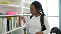 African american woman student looking for book at university classroom Royalty Free Stock Photo