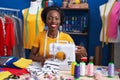 African american woman tailor smiling confident using sewing machine at sewing studio Royalty Free Stock Photo