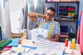African american woman tailor stressed using sewing machine at tailor shop Royalty Free Stock Photo