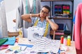 African american woman tailor stressed using sewing machine at tailor shop Royalty Free Stock Photo
