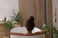 African American woman taking bath indoors, back view Royalty Free Stock Photo