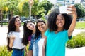 African american woman taking selfie with phone and international girlfriends Royalty Free Stock Photo