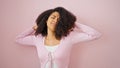 African american woman tired stretching back over isolated pink background