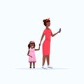 African american woman using cellphone while walking with little child daughter want attention from mother smartphone