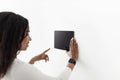African american woman using digital tablet with blank black screen with smart home control system app, mockup Royalty Free Stock Photo