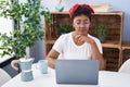 African american woman using laptop and drinking coffee sitting on table at home Royalty Free Stock Photo