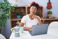 African american woman using laptop and drinking coffee sitting on table at home Royalty Free Stock Photo