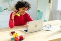 African american woman using laptop shopping online paying with gold credit card. Girl sitting at home buying on Royalty Free Stock Photo