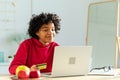 African american woman using laptop shopping online paying with gold credit card. Girl sitting at home buying on Royalty Free Stock Photo