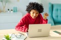 African american woman using laptop shopping online paying with gold credit card. Girl sitting at home buying on Royalty Free Stock Photo