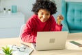 African american woman using laptop shopping online paying with gold credit card. Girl sitting at home buying on Royalty Free Stock Photo