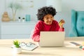 African american woman using laptop shopping online paying with gold credit card. Girl sitting at home buying on Royalty Free Stock Photo