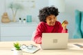 African american woman using laptop shopping online paying with gold credit card. Girl sitting at home buying on Royalty Free Stock Photo