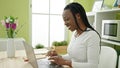 African american woman using laptop sitting on table at home Royalty Free Stock Photo