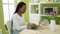 African american woman using laptop sitting on table at home Royalty Free Stock Photo