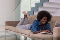 African American woman using laptop on sofa Royalty Free Stock Photo