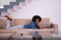 African American woman using laptop on sofa Royalty Free Stock Photo