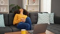 African american woman using laptop suffering for stomach pain at home Royalty Free Stock Photo