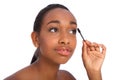 African American woman using mascara brush