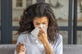 African American woman is very sick measures temperature, feels very bad. Young ill female blows his nose in a napkin Royalty Free Stock Photo