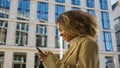 African American woman walks typing messages on phone