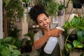 African american woman watering plants in botany shop Royalty Free Stock Photo