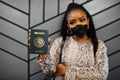 African american woman wearing black face mask show Mexico passport in hand. Coronavirus in America country, border closure and