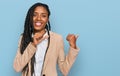 African american woman wearing business jacket pointing to the back behind with hand and thumbs up, smiling confident