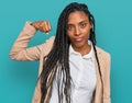 African american woman wearing business jacket strong person showing arm muscle, confident and proud of power