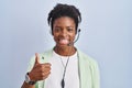 African american woman wearing call center agent headset doing happy thumbs up gesture with hand Royalty Free Stock Photo