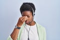 African american woman wearing call center agent headset tired rubbing nose and eyes feeling fatigue and headache Royalty Free Stock Photo