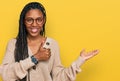 African american woman wearing casual clothes showing palm hand and doing ok gesture with thumbs up, smiling happy and cheerful Royalty Free Stock Photo