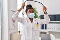 African american woman wearing doctor uniform and medical mask holding stethoscope at clinic Royalty Free Stock Photo