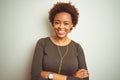 African american woman wearing earphones listening to music over isolated background happy face smiling with crossed arms looking Royalty Free Stock Photo