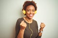 African american woman wearing headphones listening to music over isolated background celebrating surprised and amazed for success Royalty Free Stock Photo