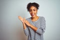 African american woman wearing navy striped t-shirt standing over isolated white background clapping and applauding happy and Royalty Free Stock Photo