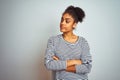 African american woman wearing navy striped t-shirt standing over isolated white background looking to the side with arms crossed Royalty Free Stock Photo