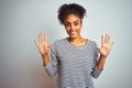 African american woman wearing navy striped t-shirt standing over isolated white background showing and pointing up with fingers Royalty Free Stock Photo