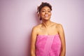 African american woman wearing shower towel after bath over pink isolated background with a happy and cool smile on face Royalty Free Stock Photo