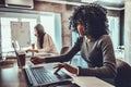 African american woman worker or student studying working with laptop holding pen making notes Royalty Free Stock Photo