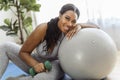 African american woman working out in home livingroom gym with training ball